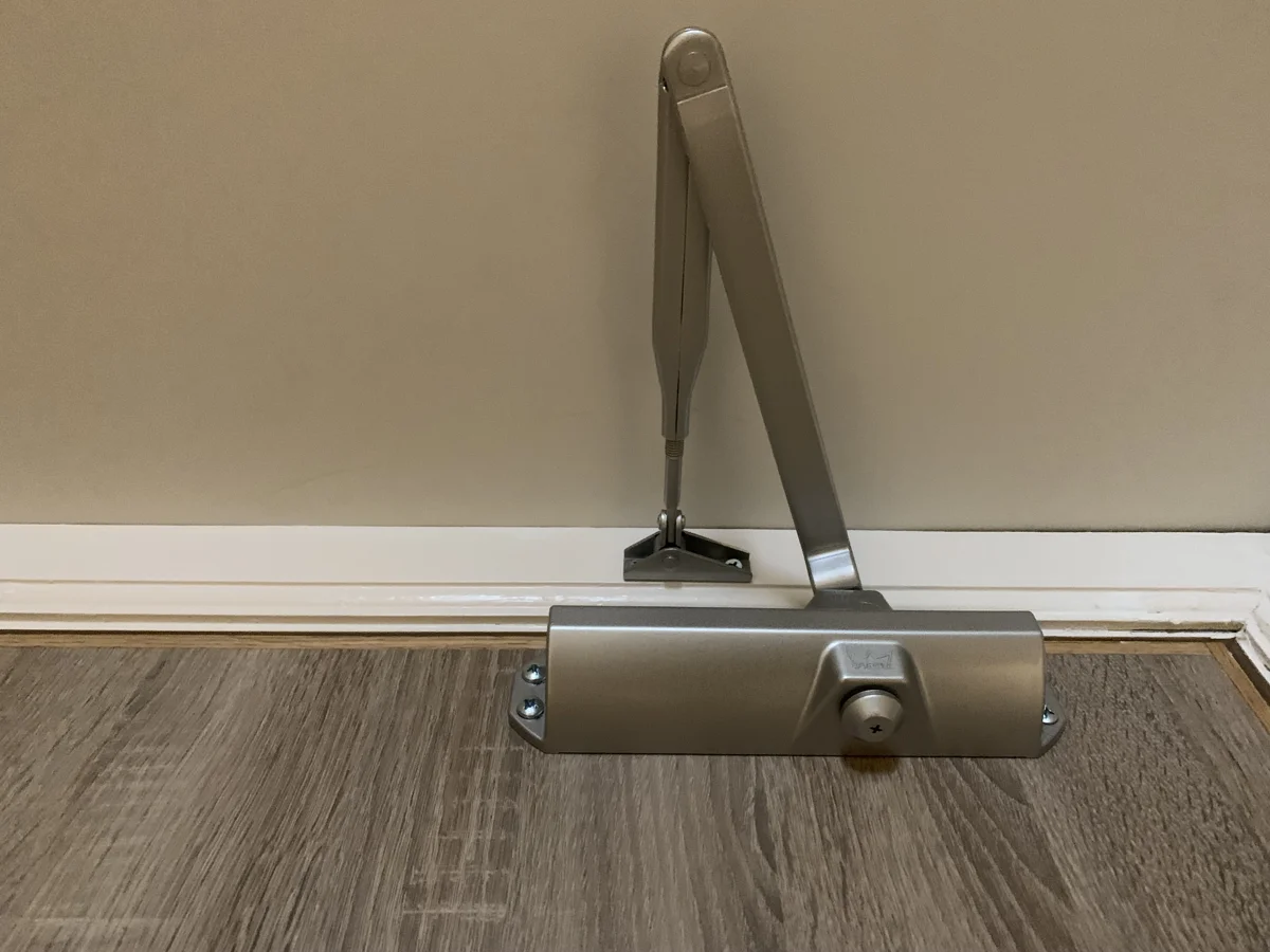A door closer fitted above a timber door